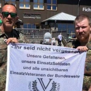Helfer präsentieren Unterstützungsbanner für Einsatzsoldaten und Veteranen