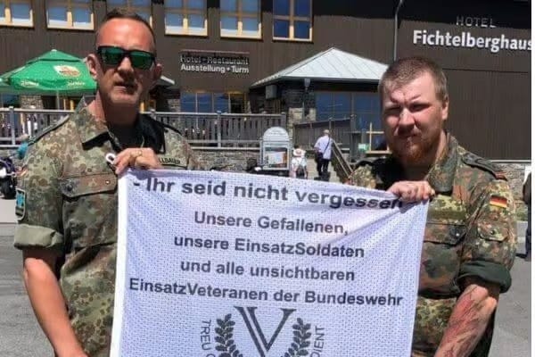 Helfer präsentieren Unterstützungsbanner für Einsatzsoldaten und Veteranen